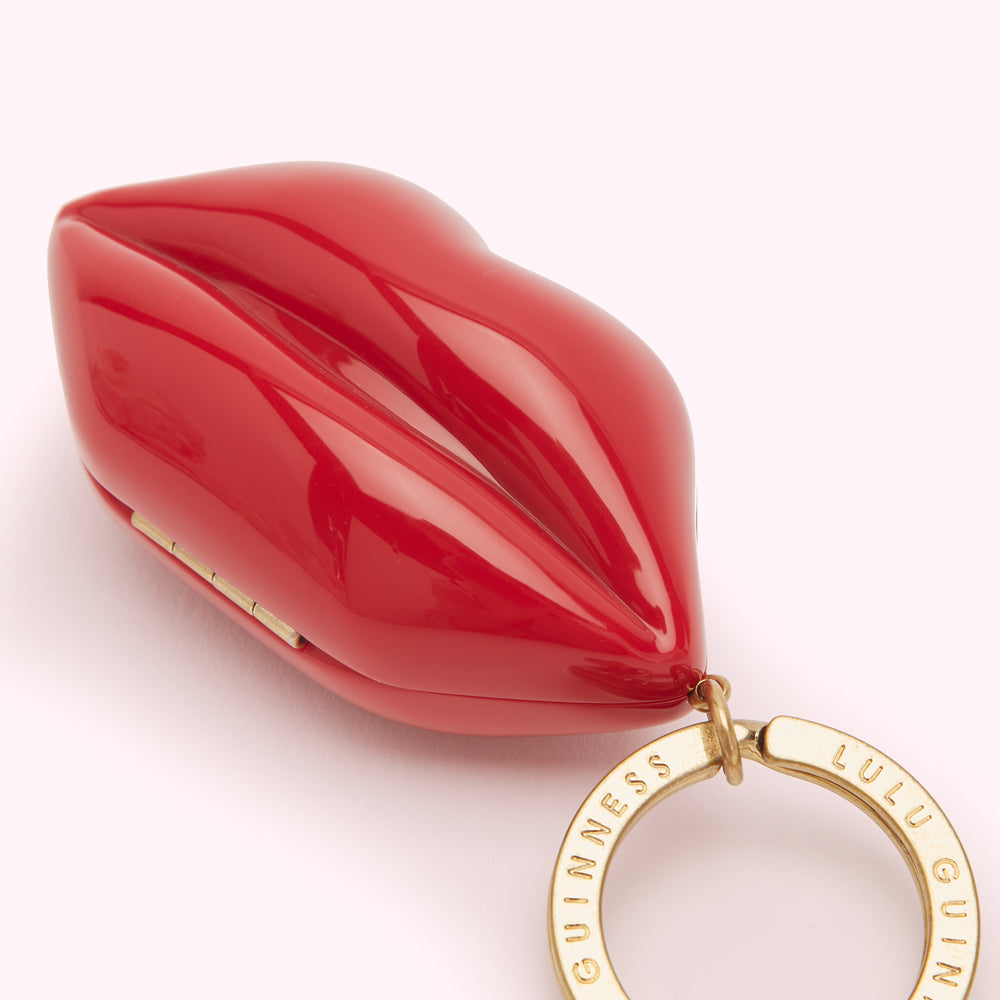 Red lip-shaped keyring with gold Lulu Guinness branding.
