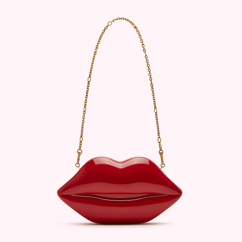Red lips-shaped clutch with gold chain strap.

