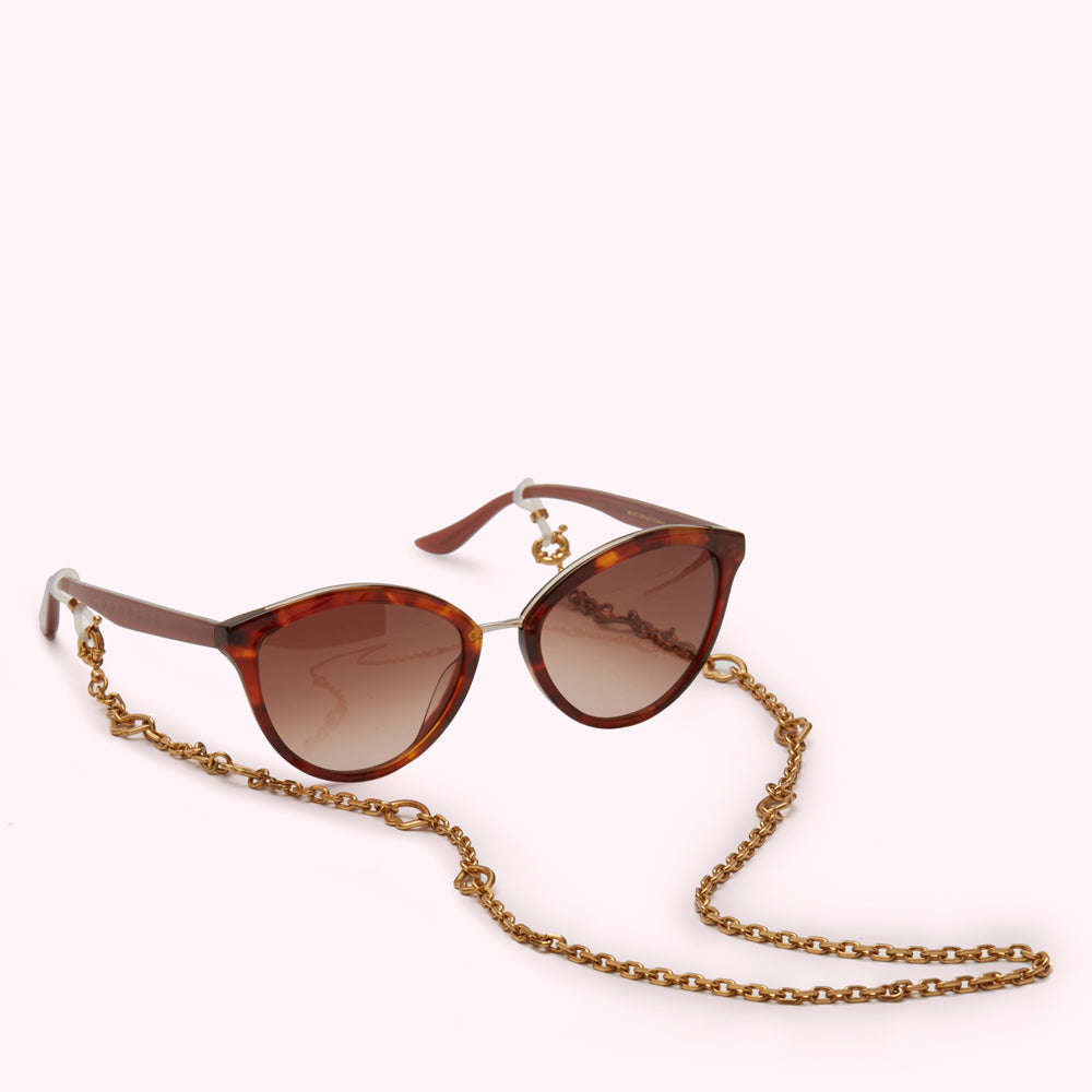 Brown tortoiseshell sunglasses with gold chain.
