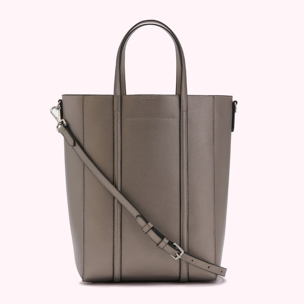 A taupe leather tote bag with a long shoulder strap.
