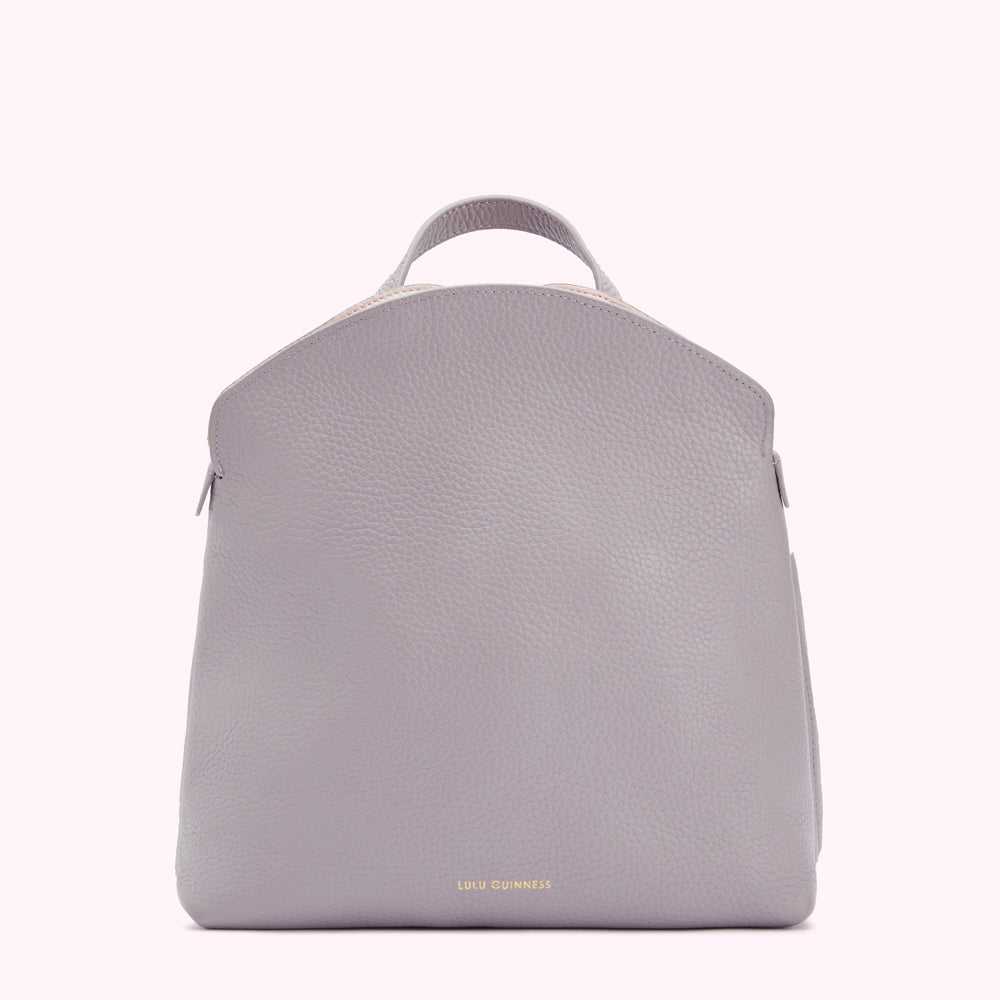 Lilac Lulu Guinness leather backpack with a curved top.
