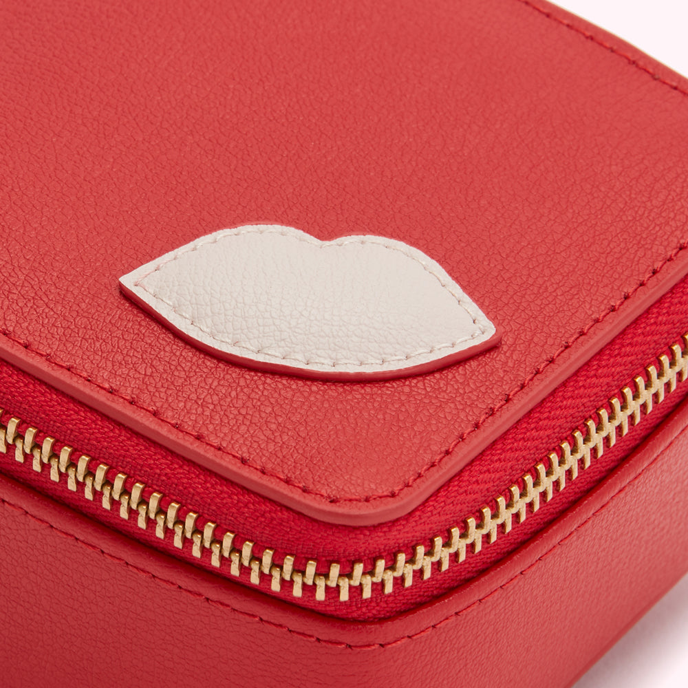 Red leather jewelry box with a cream-colored lip design.