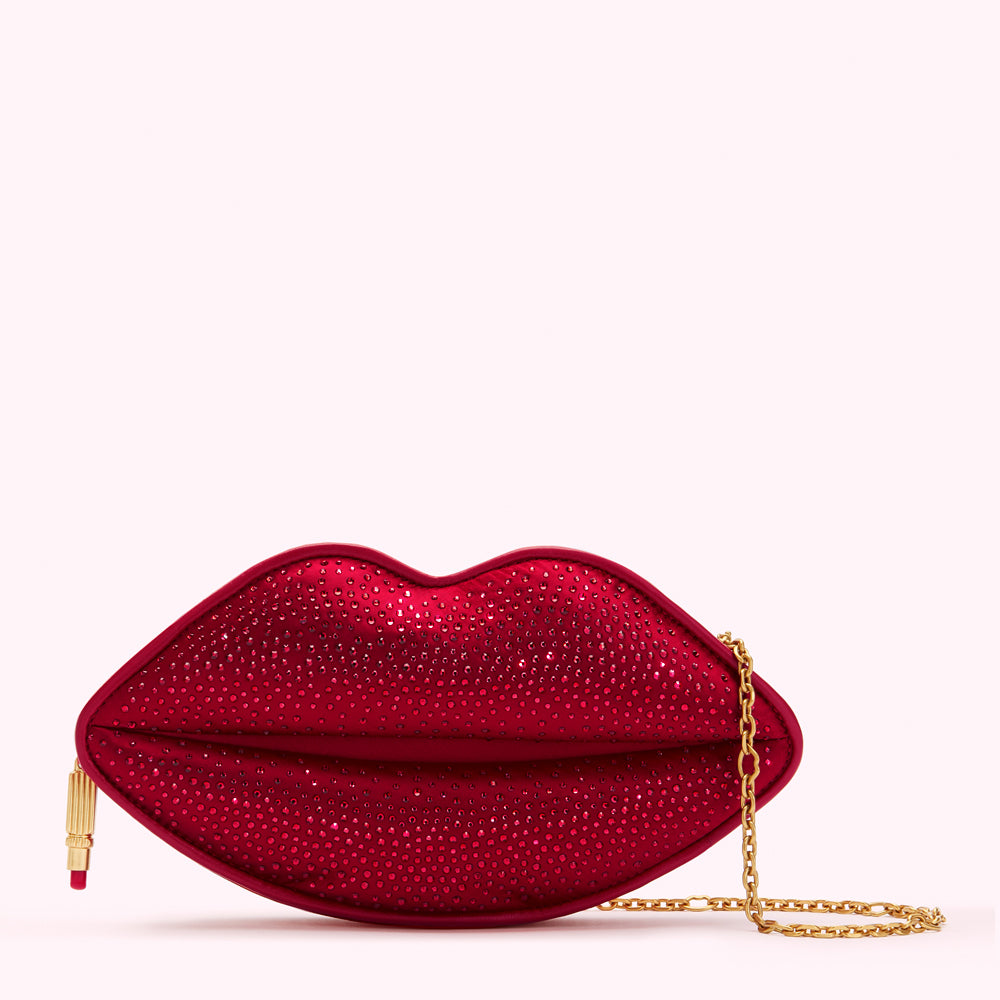 Red lip-shaped clutch embellished with crystals and a gold chain strap.