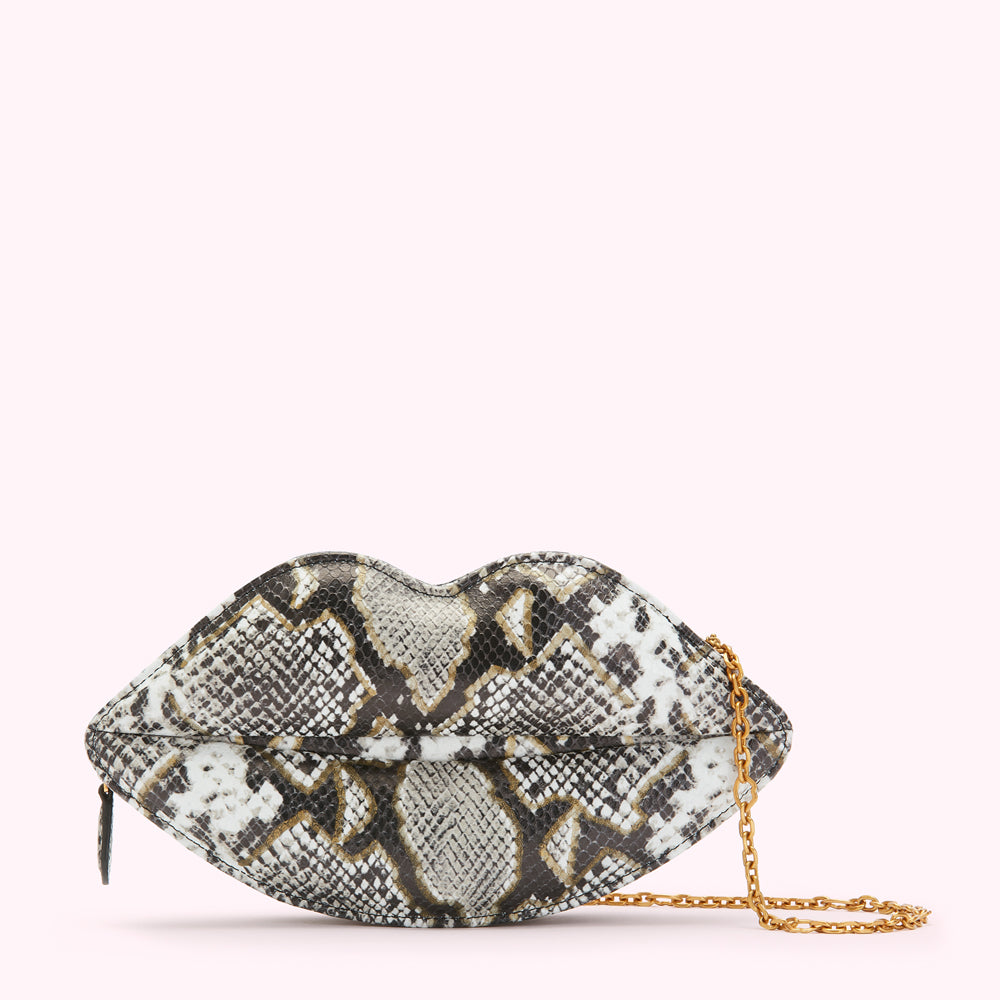 Snakeskin-print lip-shaped clutch with gold chain strap against a white background.
