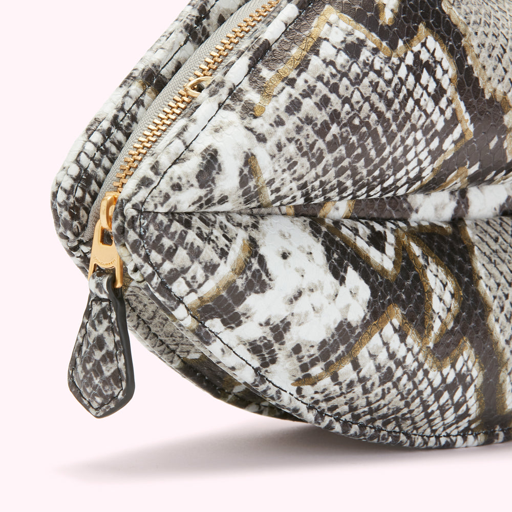 Close-up of a gray and white snakeskin-textured cosmetic bag with gold accents and a gold zipper.