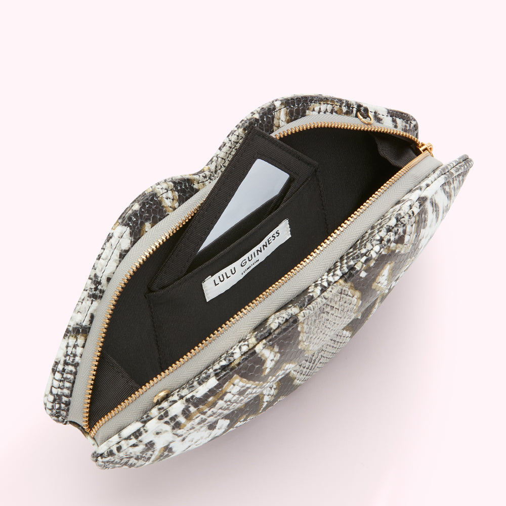 Open Lulu Guinness lip-shaped clutch in snakeskin print, showing black interior with zipper and small pocket.