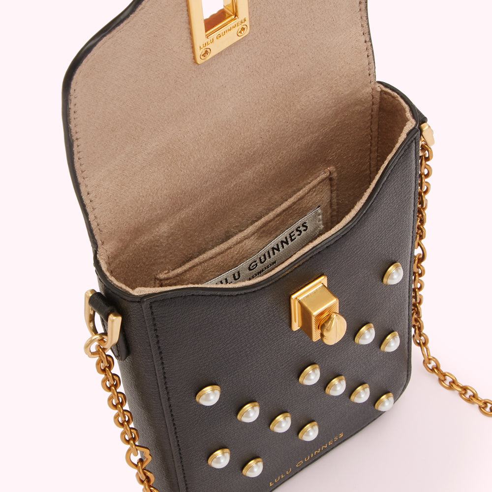 Black Lulu Guinness crossbody bag with pearl detailing and gold chain strap, shown open to reveal the interior.
