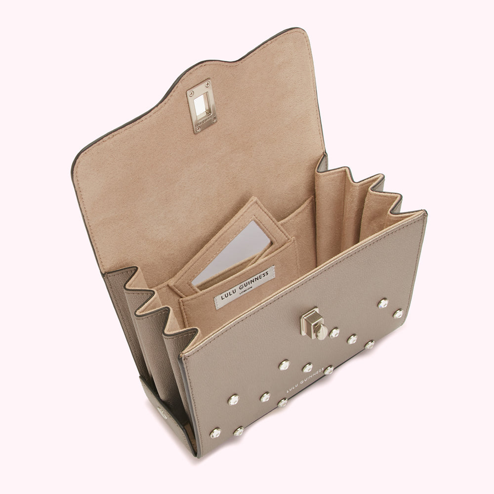 Open taupe Lulu Guinness crossbody bag with studded detailing and beige interior.