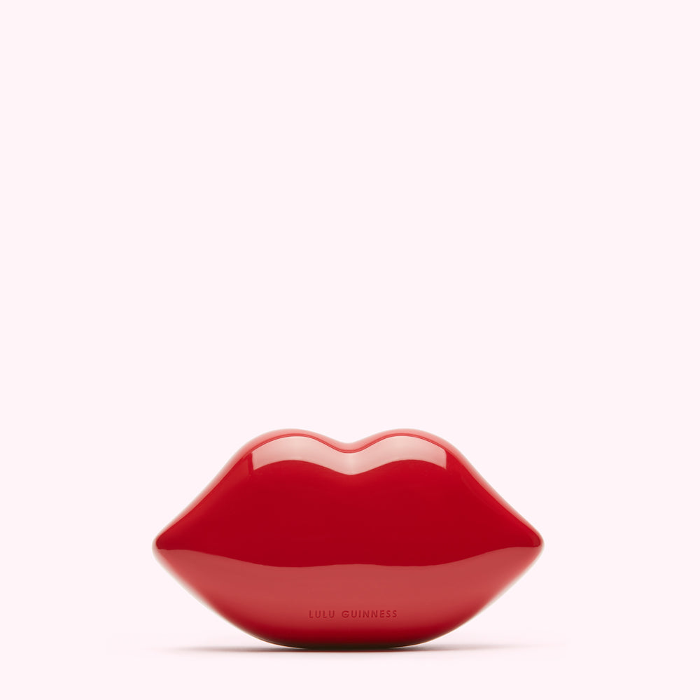 Red Lulu Guinness lip-shaped clutch bag on white background.
