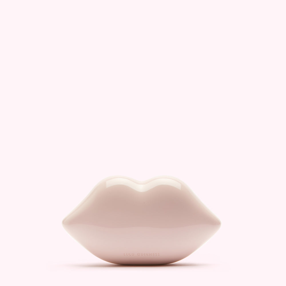 Pink Lulu Guinness lips clutch bag against a white background.
