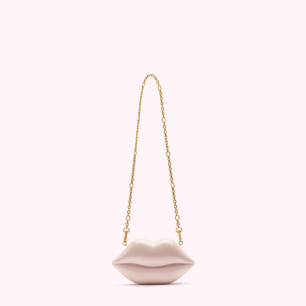 Pink lip-shaped clutch with gold chain strap.
