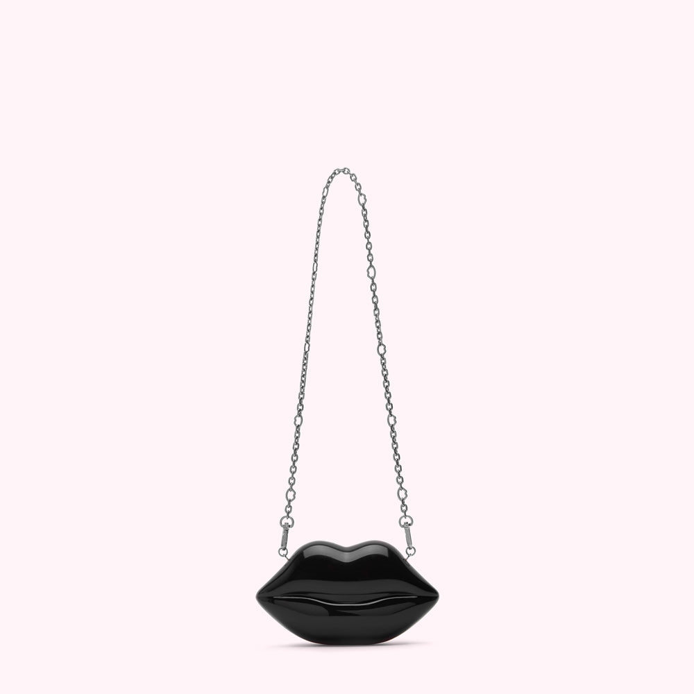 Black lip-shaped purse with a silver chain strap against a white background.
