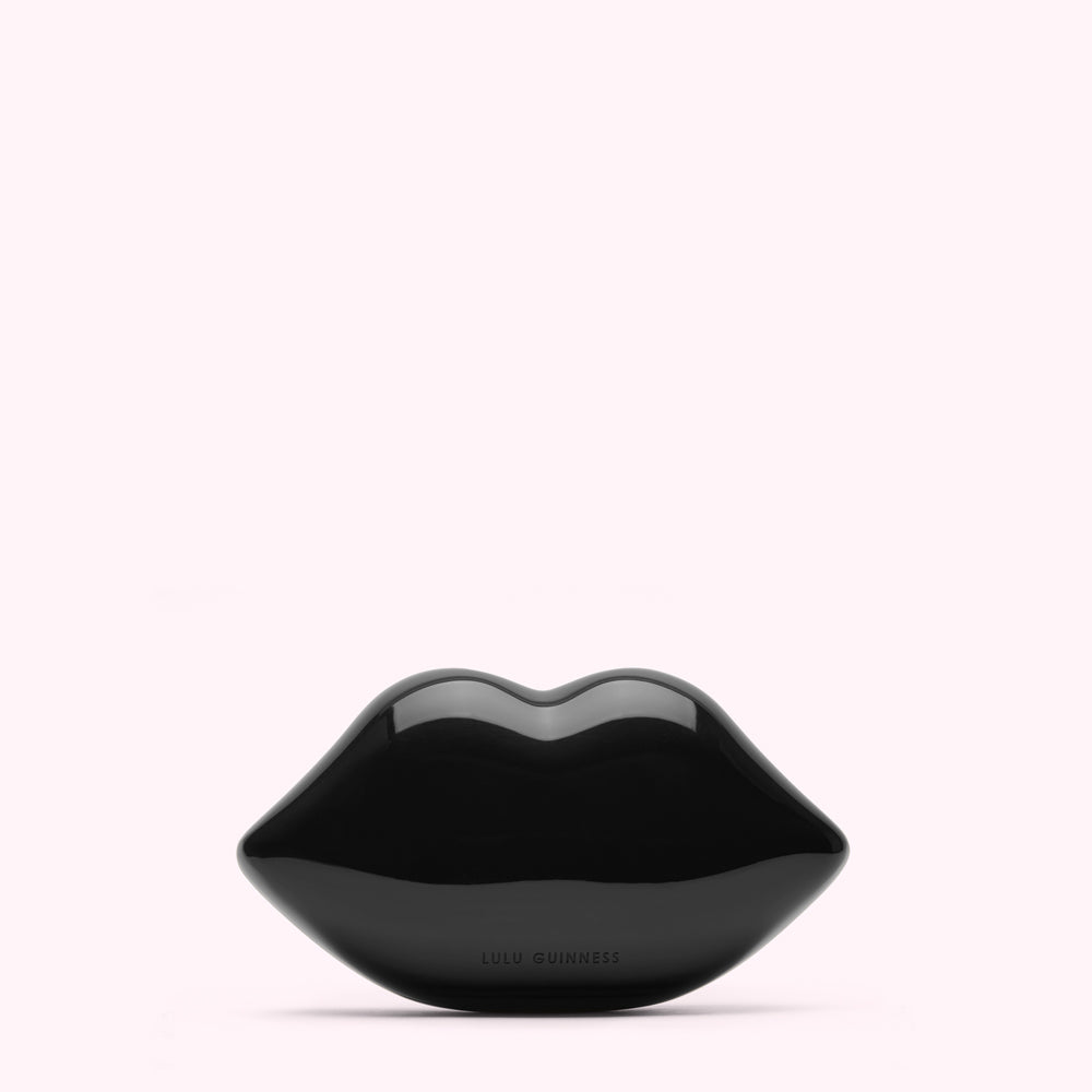 Black Lulu Guinness lips clutch bag against a white background.
