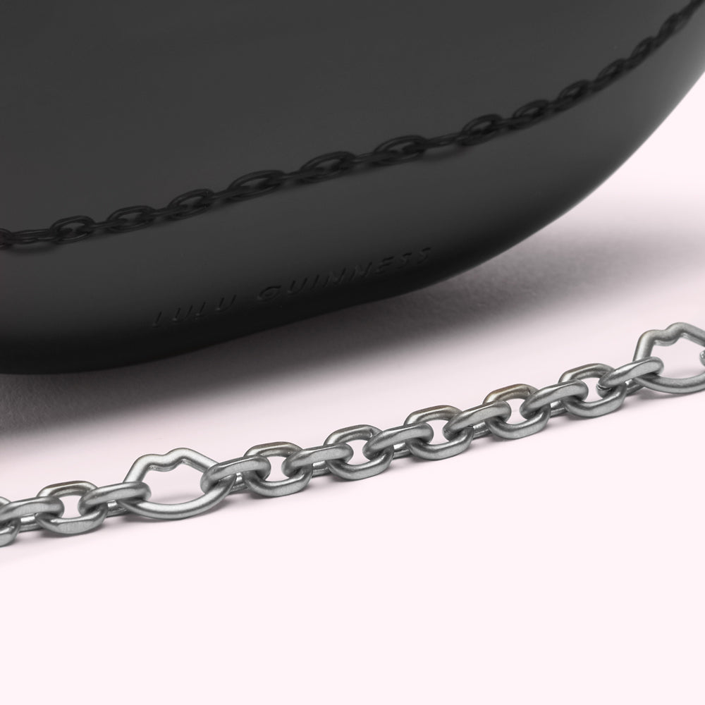 Close-up of a black Lulu Guinness bag with a silver chain strap.