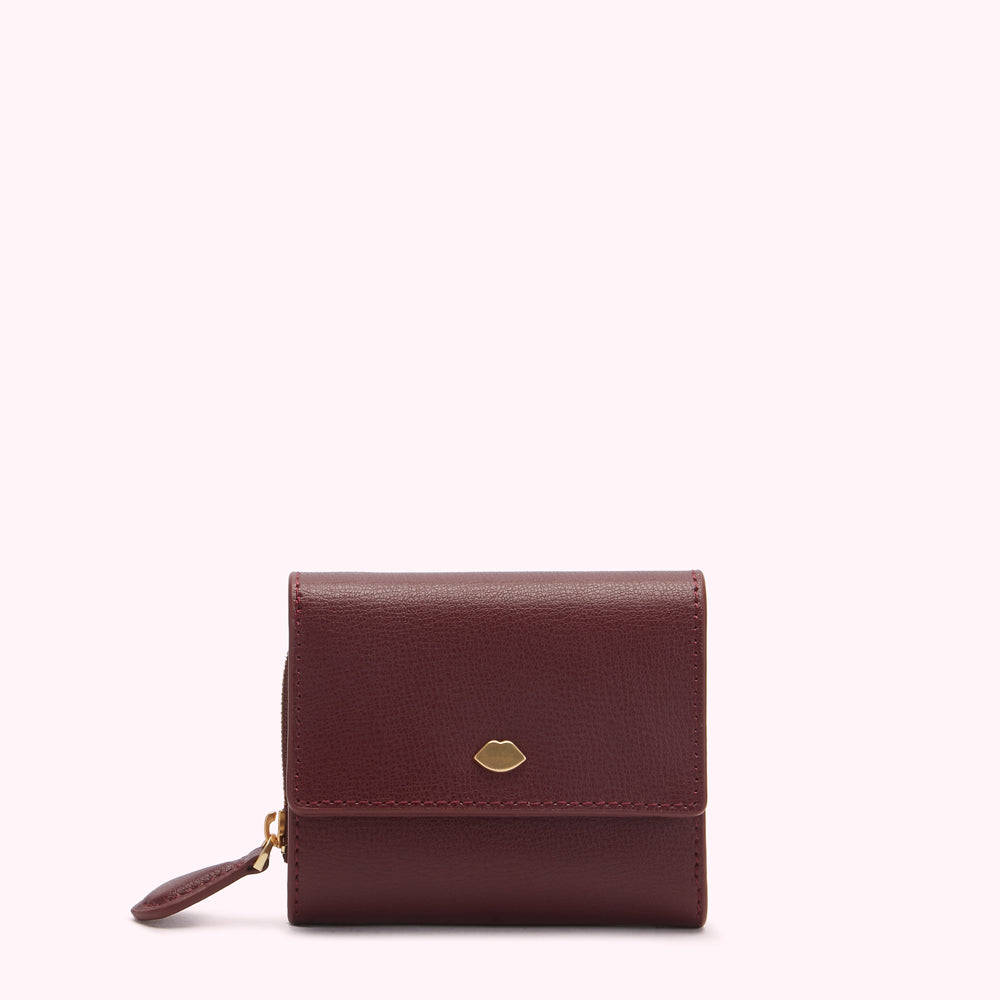 A burgundy leather wallet with a gold lip logo.
