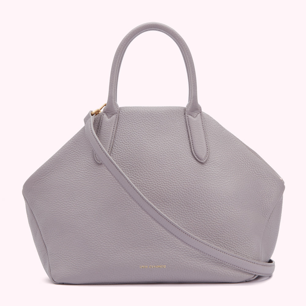 A light grey leather handbag with two top handles and a long shoulder strap.
