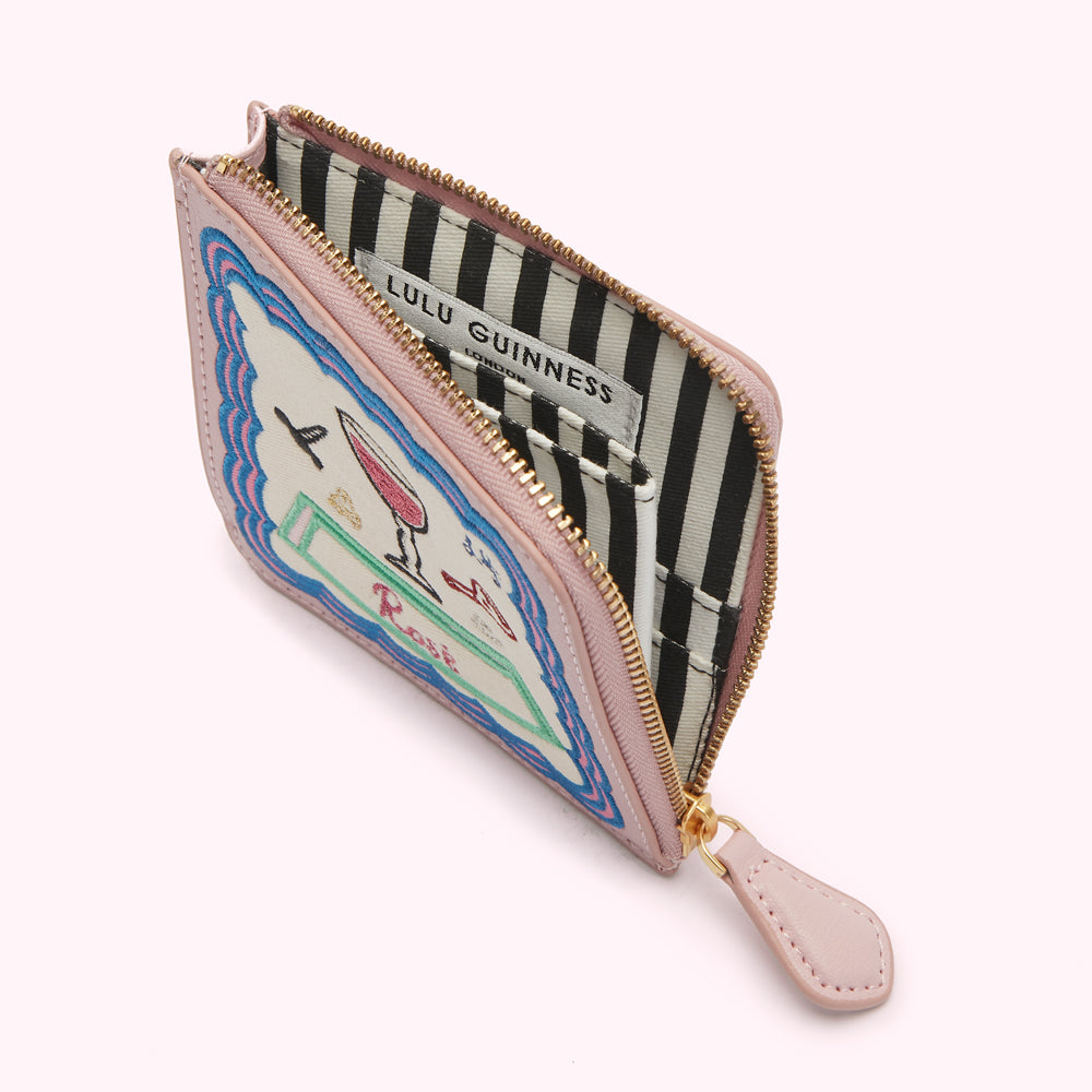 Pink Lulu Guinness zip-around purse with embroidered rose illustration; open to reveal black and white striped interior.