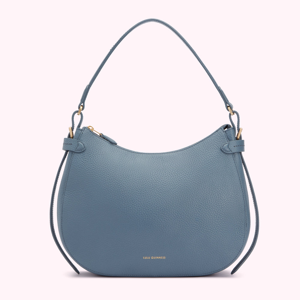 A dusty blue Lulu Guinness crescent-shaped handbag with gold hardware.