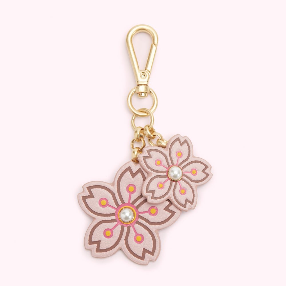 Pink leather cherry blossom keychain with gold clasp.