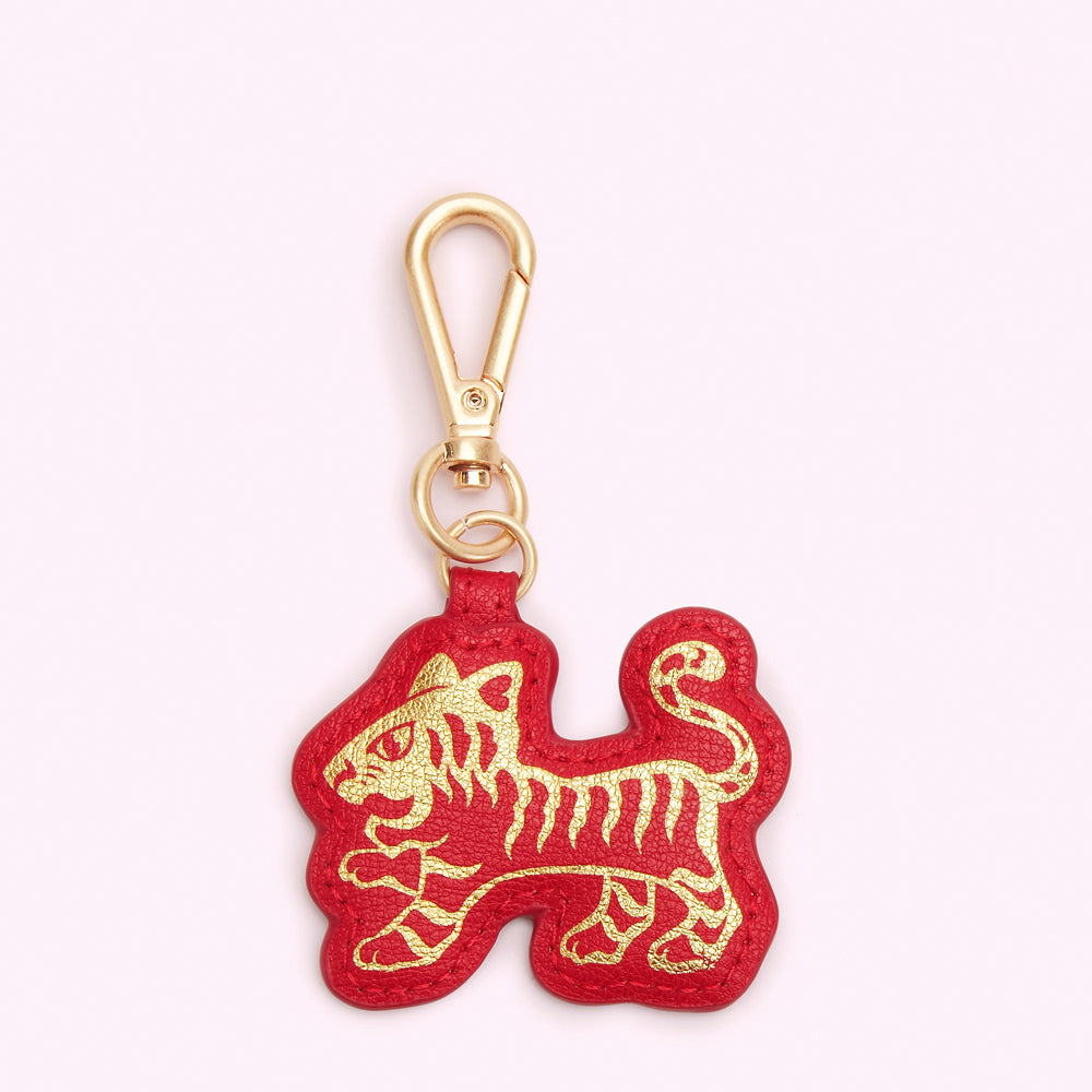 Red leather keyring in the shape of a gold tiger.
