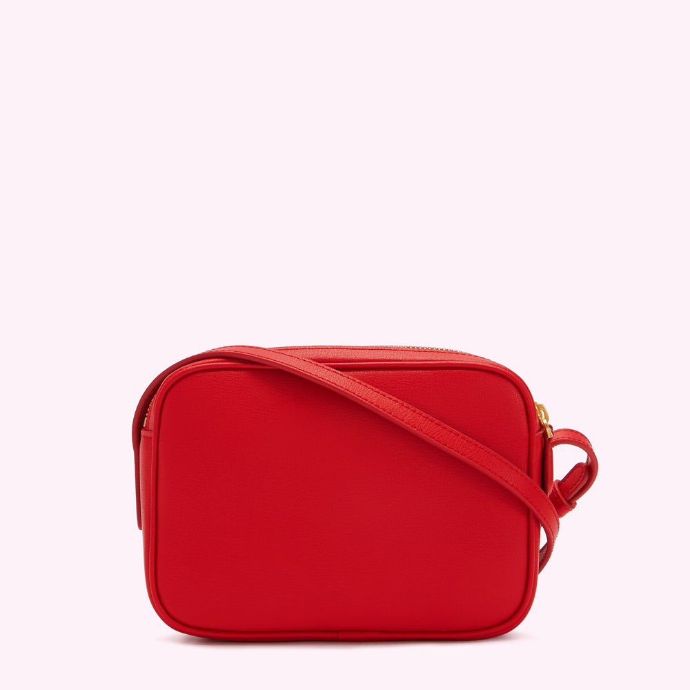 Red leather crossbody bag against a white background.
