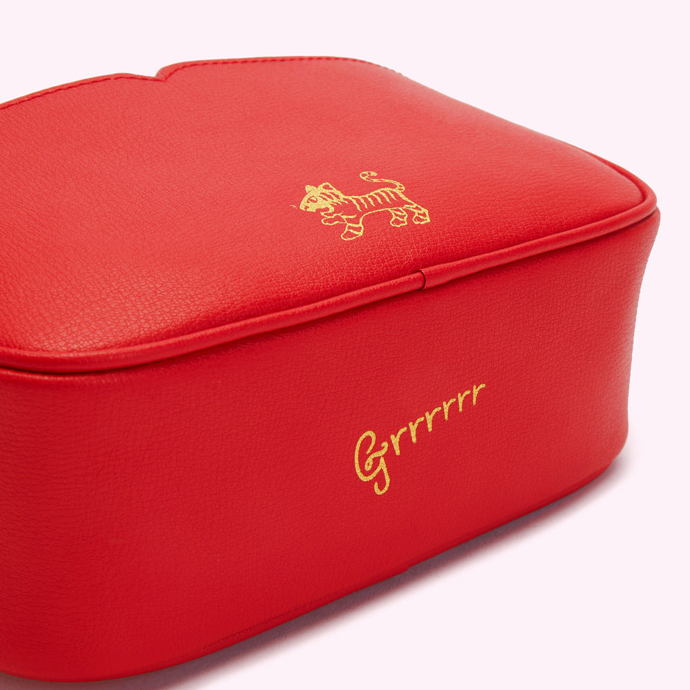 Close-up of a red leather bag with a small tiger and "Grrrrrr" gold-lettered on it.
