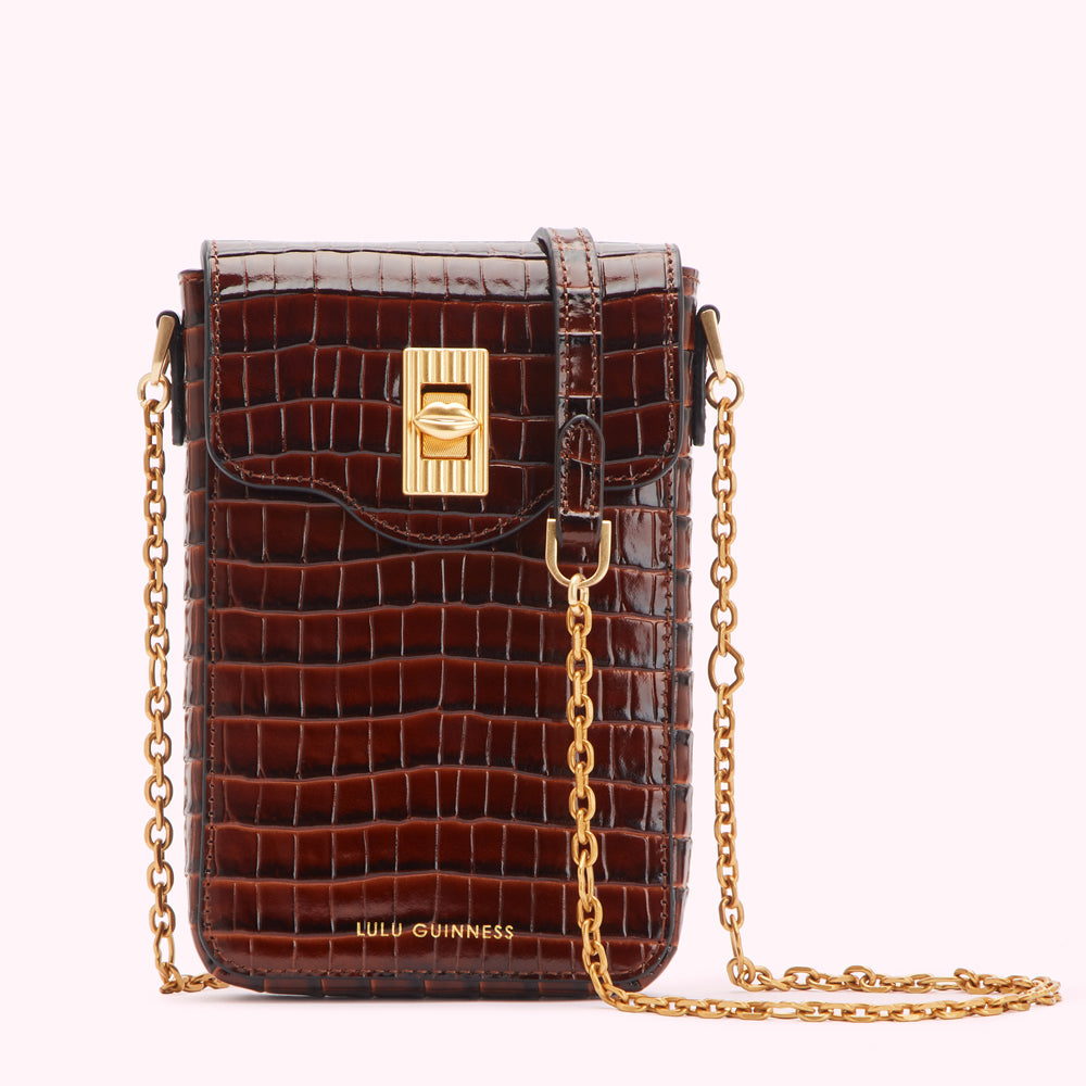 Brown croc-embossed leather crossbody bag with gold chain strap and clasp.