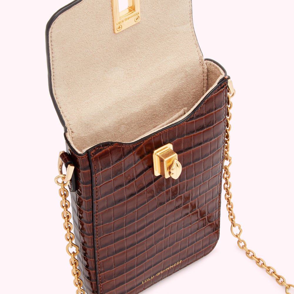 Brown crocodile-embossed leather crossbody bag with gold chain strap and clasp. The bag is open, showing a beige interior.
