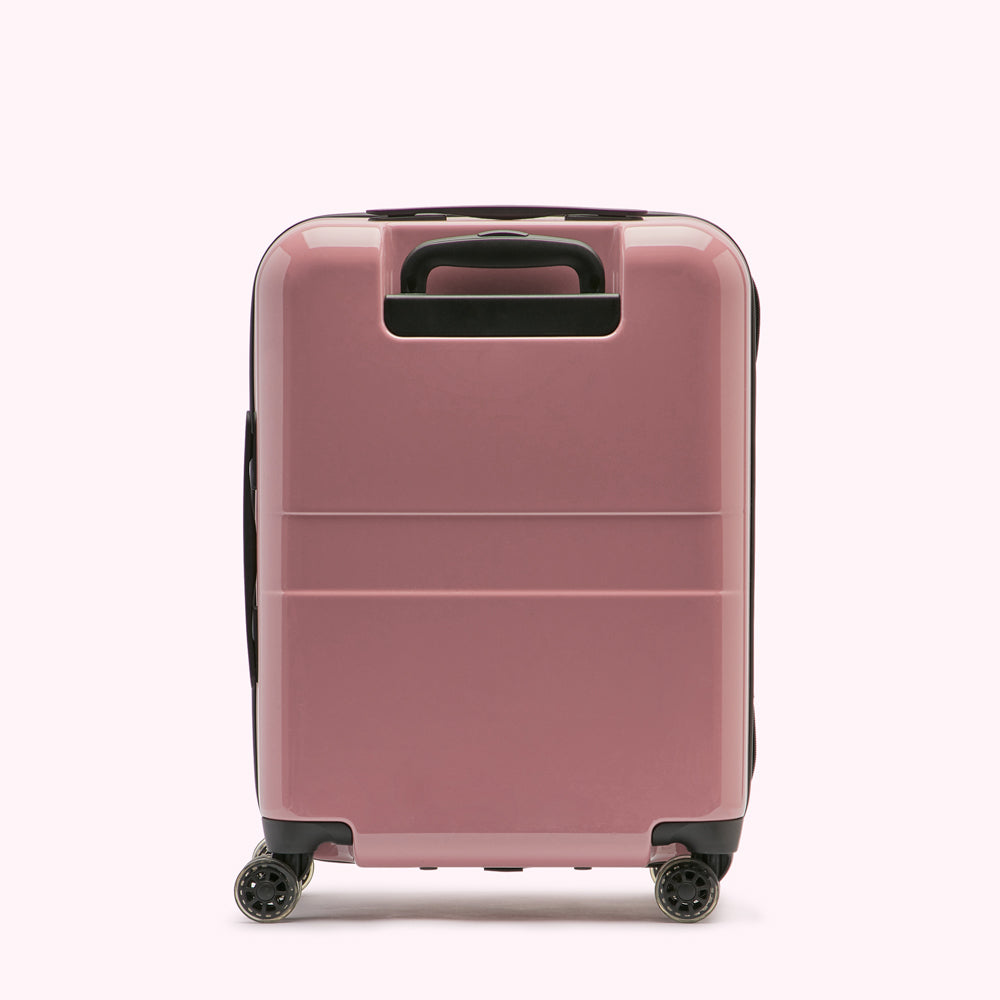 Pink carry-on suitcase on a white background.

