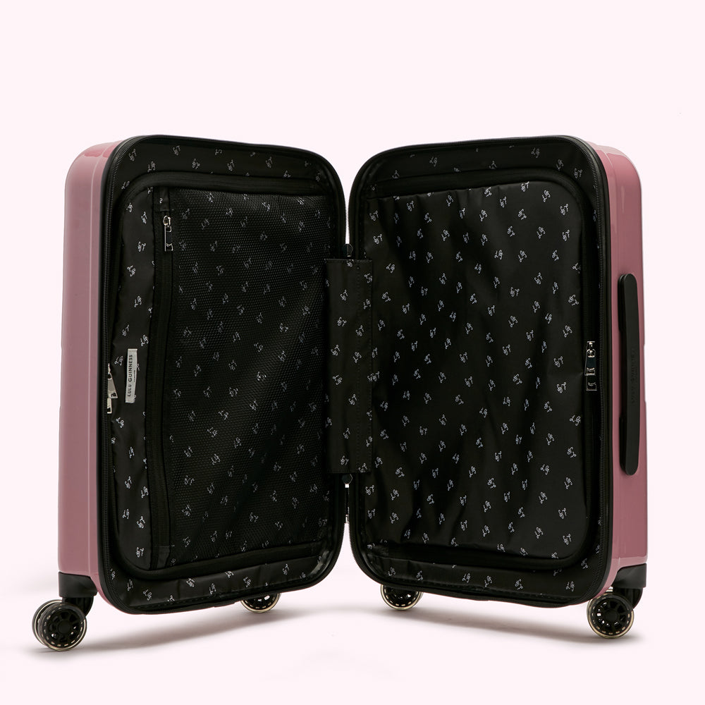Pink suitcase open to reveal its black interior with small logo print.