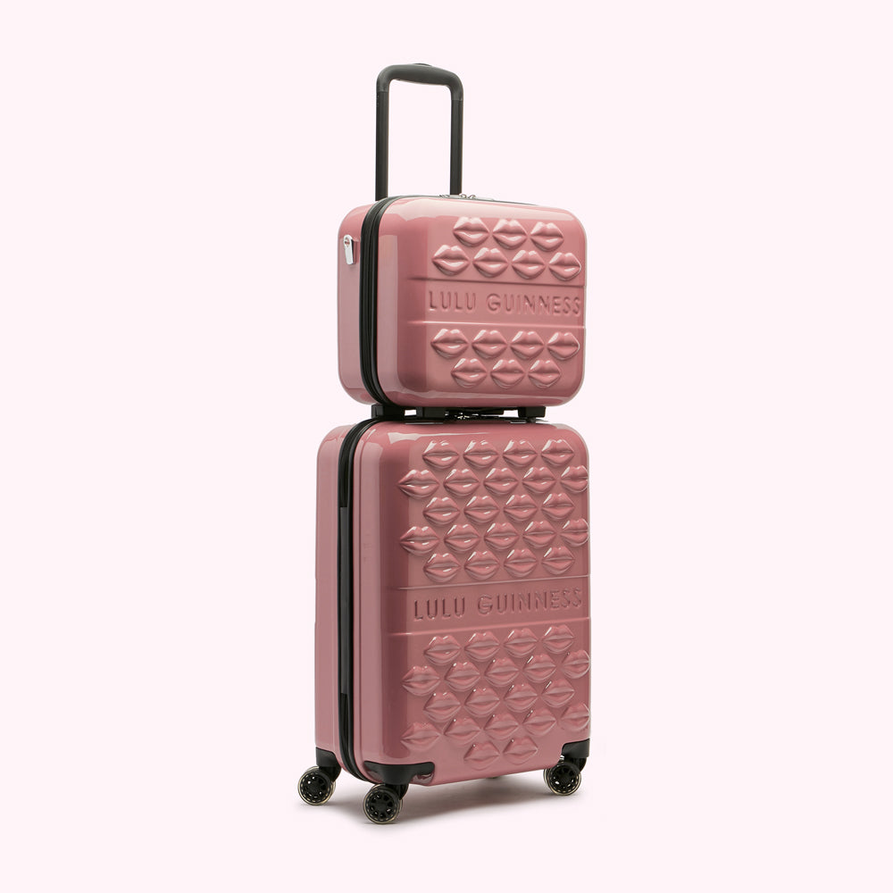 Pink Lulu Guinness luggage set with lip print.
