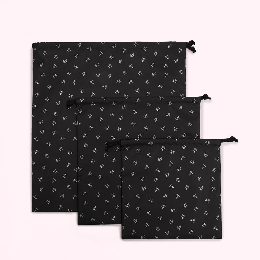 Three black drawstring bags with a repeating white logo pattern on a white background.