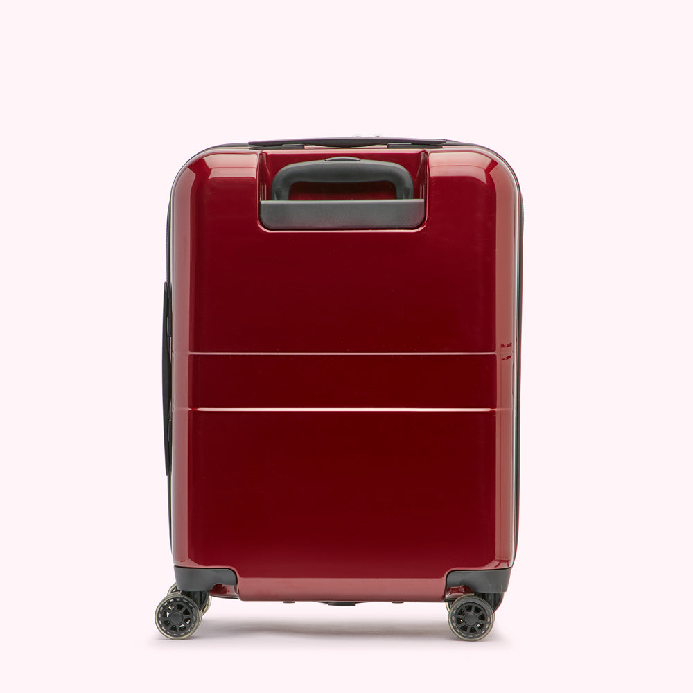 Red carry-on suitcase with black wheels and handle, shown from the back.
