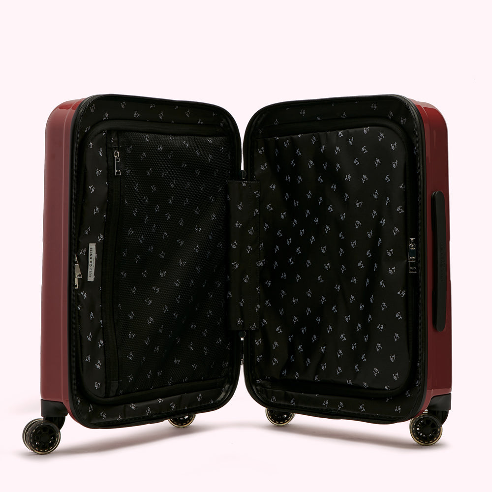 Open burgundy suitcase with black patterned lining.
