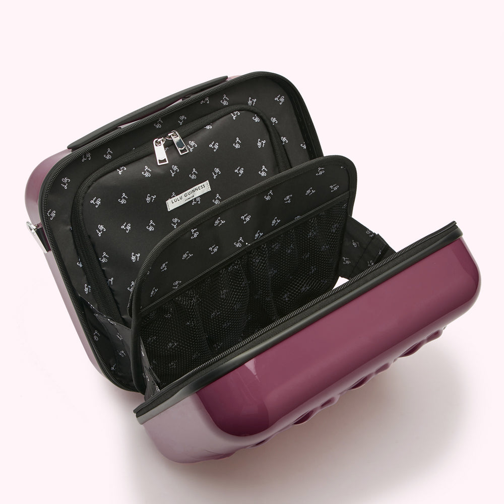 Open purple Lulu Guinness carry-on suitcase with black interior lining and compartments.