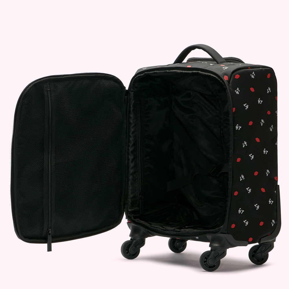 Open black carry-on suitcase with red lip print, showing interior compartments and wheels.

