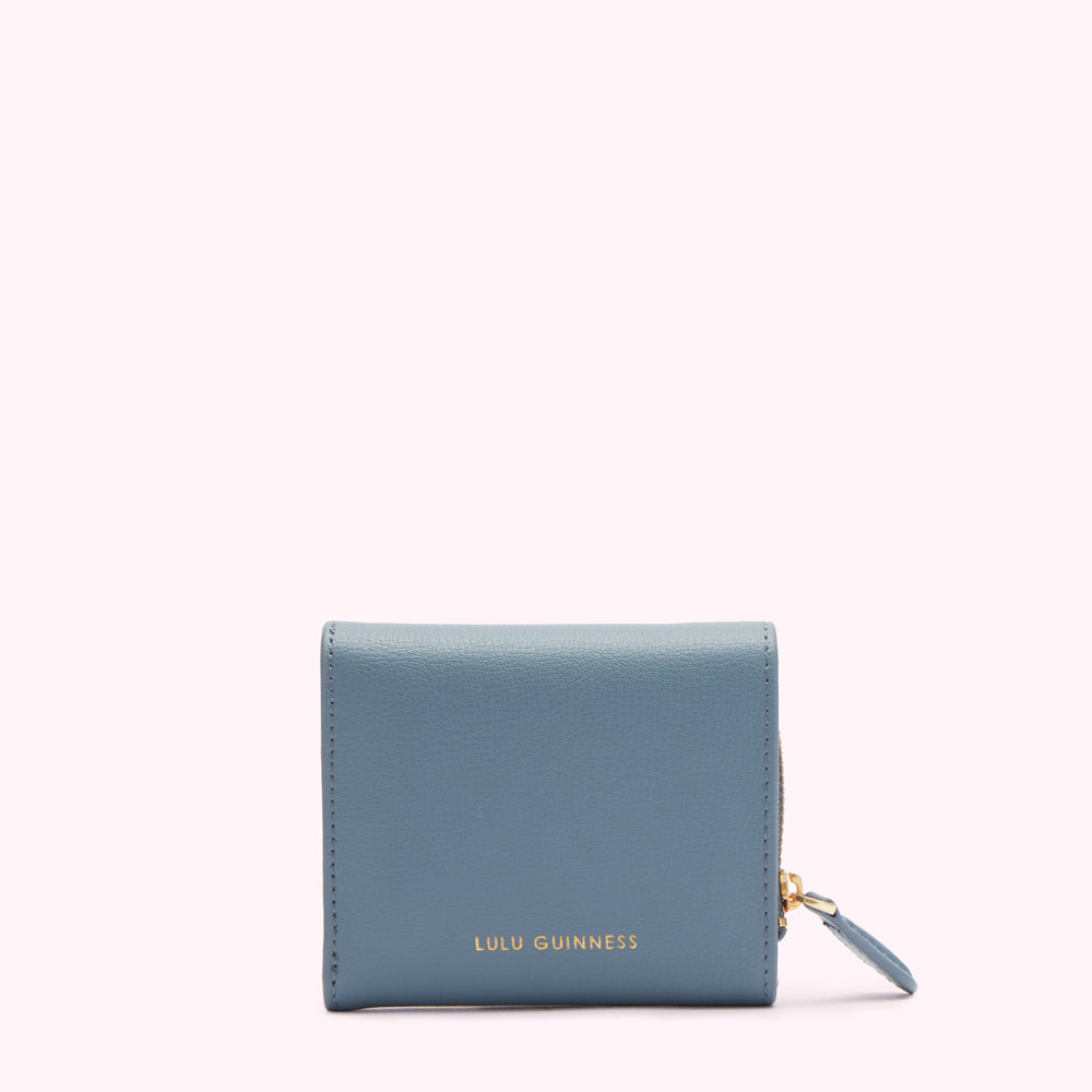 A powder blue Lulu Guinness zip-around wallet against a white background.