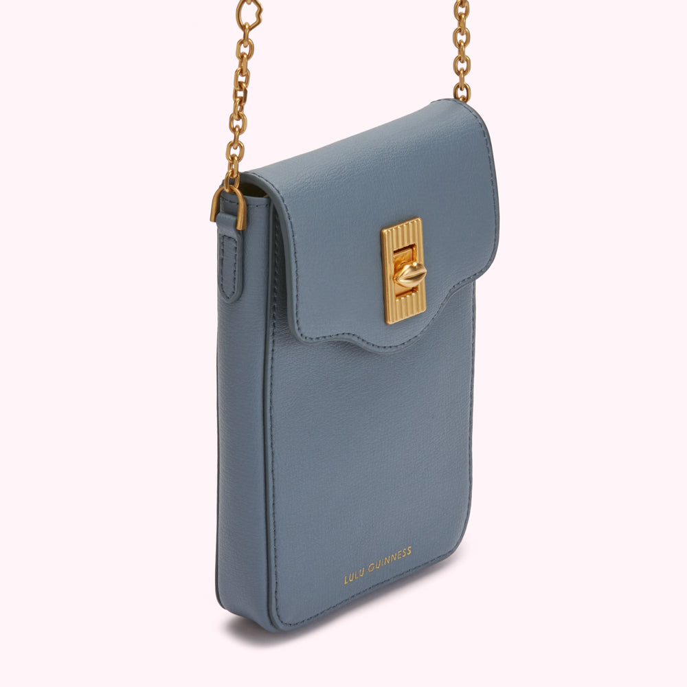 A dust-blue Lulu Guinness crossbody bag with gold chain strap and clasp.
