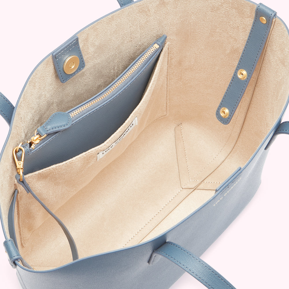 Inside of a blue Lulu Guinness tote bag showing the beige lining and an internal zipped pocket.
