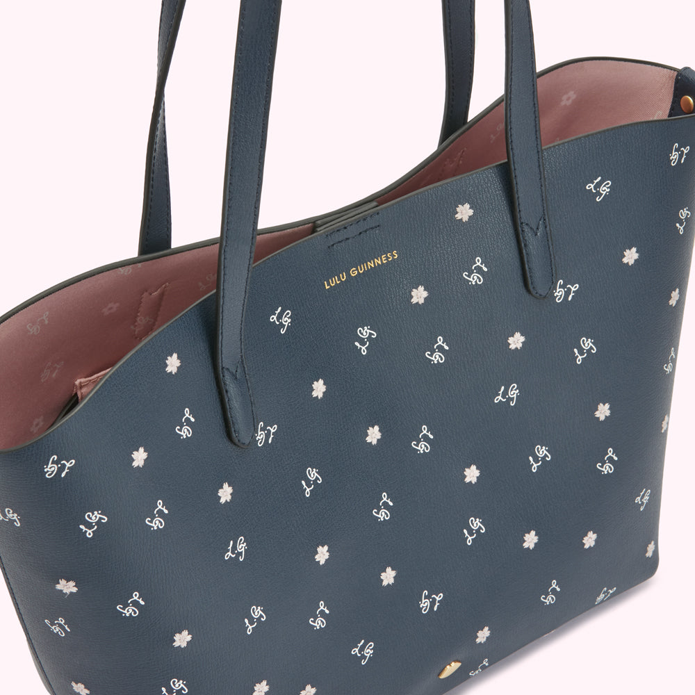 Navy blue Lulu Guinness tote bag with pink interior and white floral print.