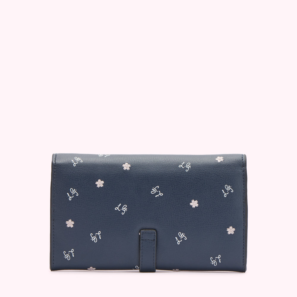Navy blue leather wallet with a repeating pattern of small white flowers and the initials "L.G." in a script font.