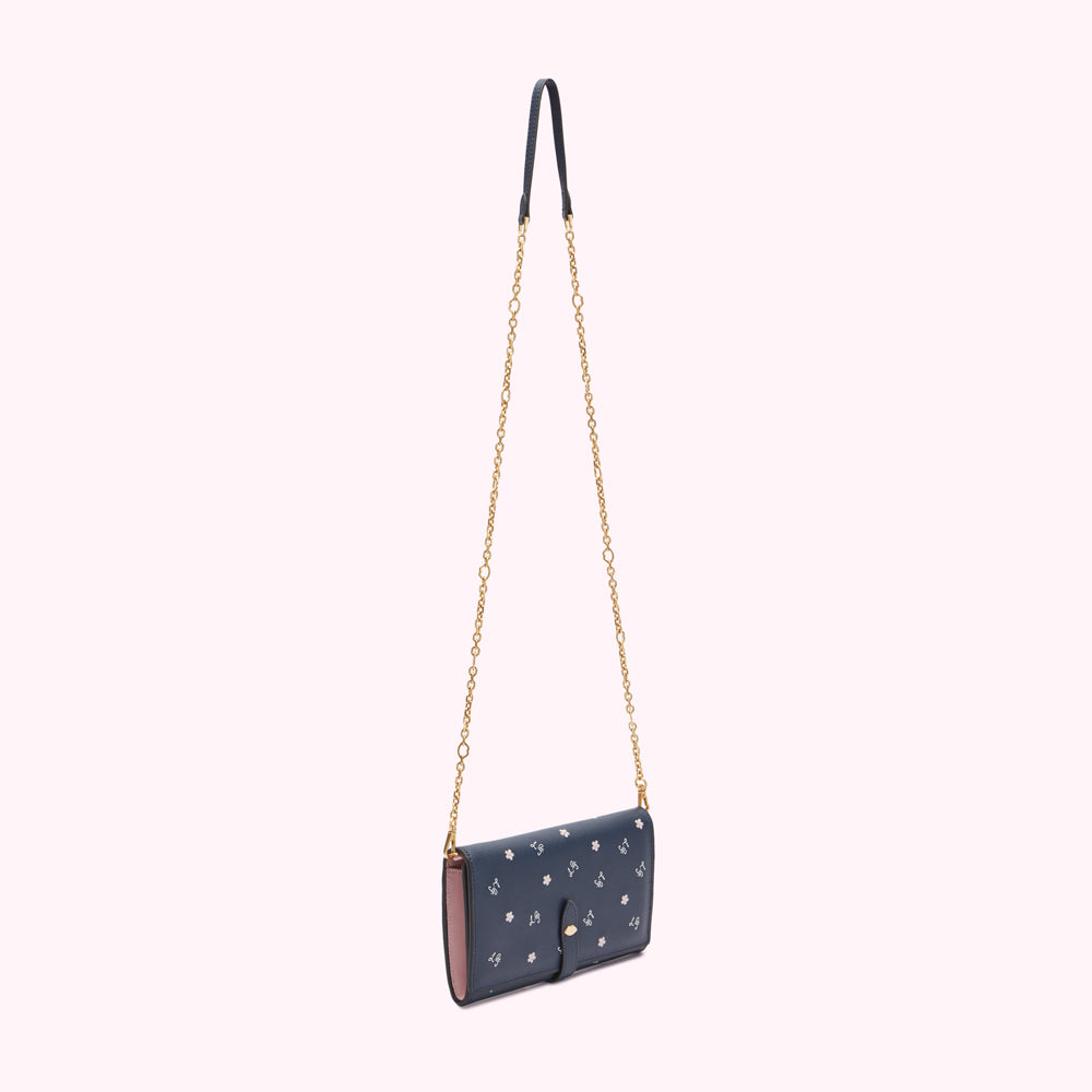 Dark blue leather wallet with a gold chain strap and small white flower details.