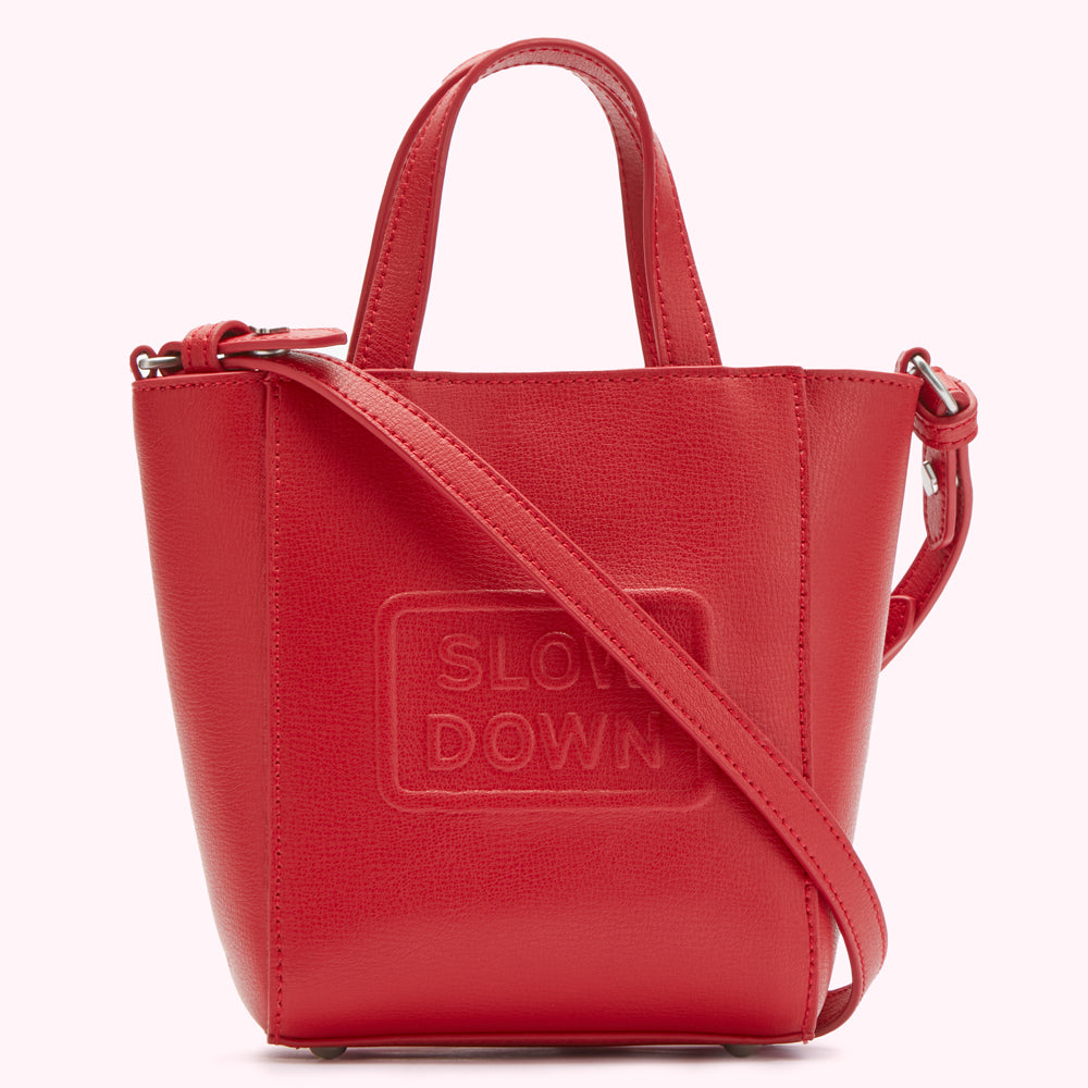 Red leather tote bag with "SLOW DOWN" embossed on the front.

