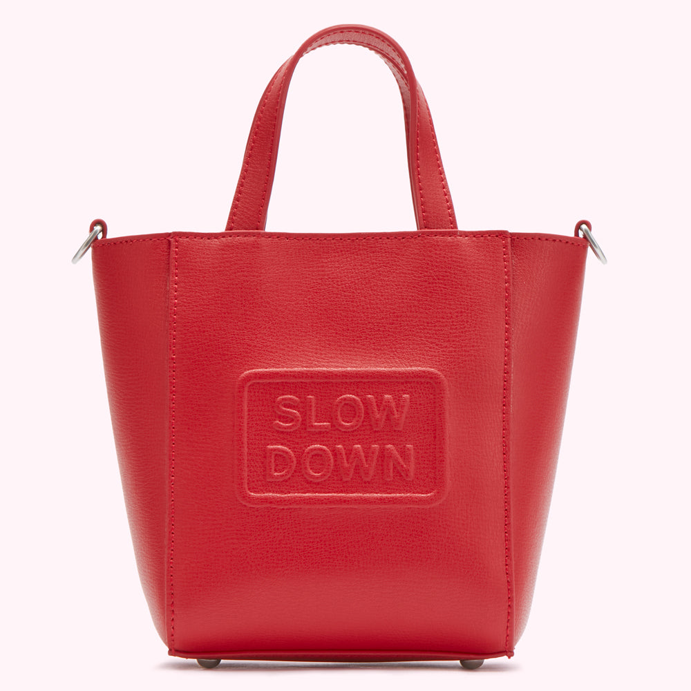 Red leather tote bag with "SLOW DOWN" embossed on the front.
