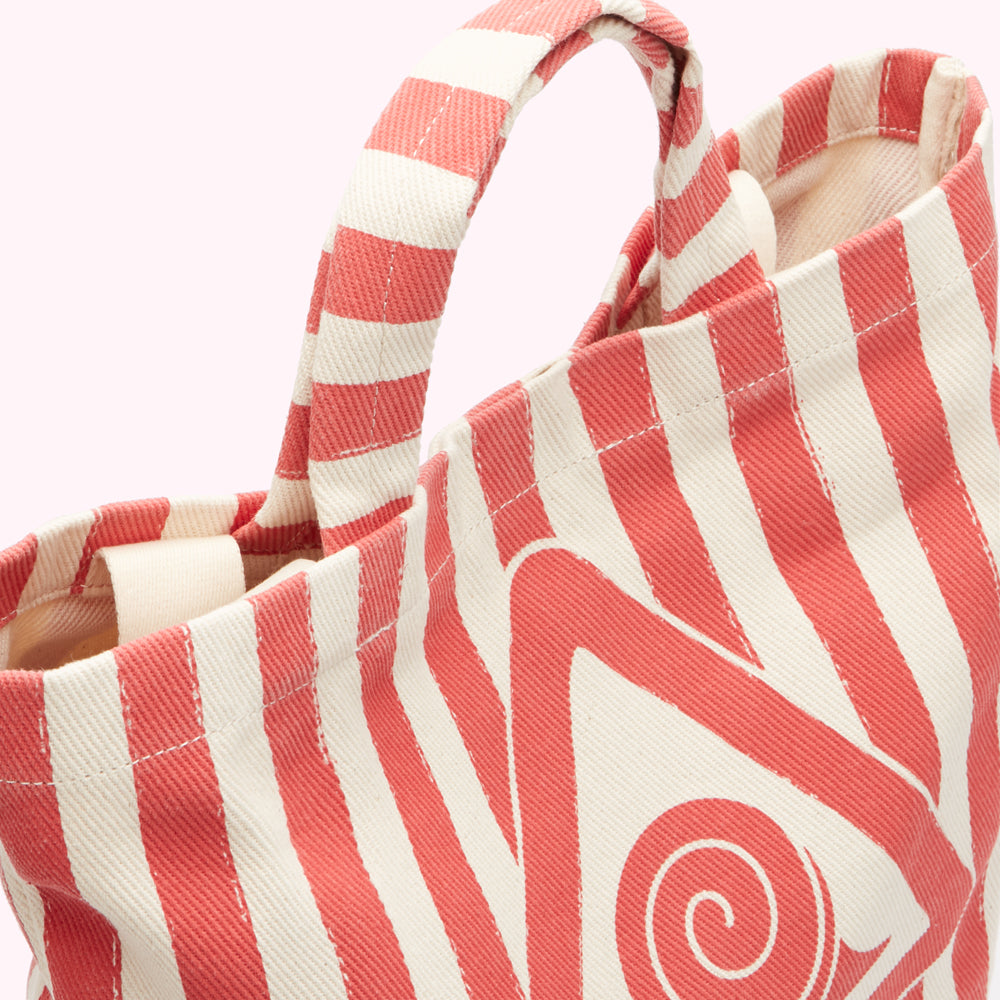 Close-up of a coral and white striped tote bag with a graphic design.

