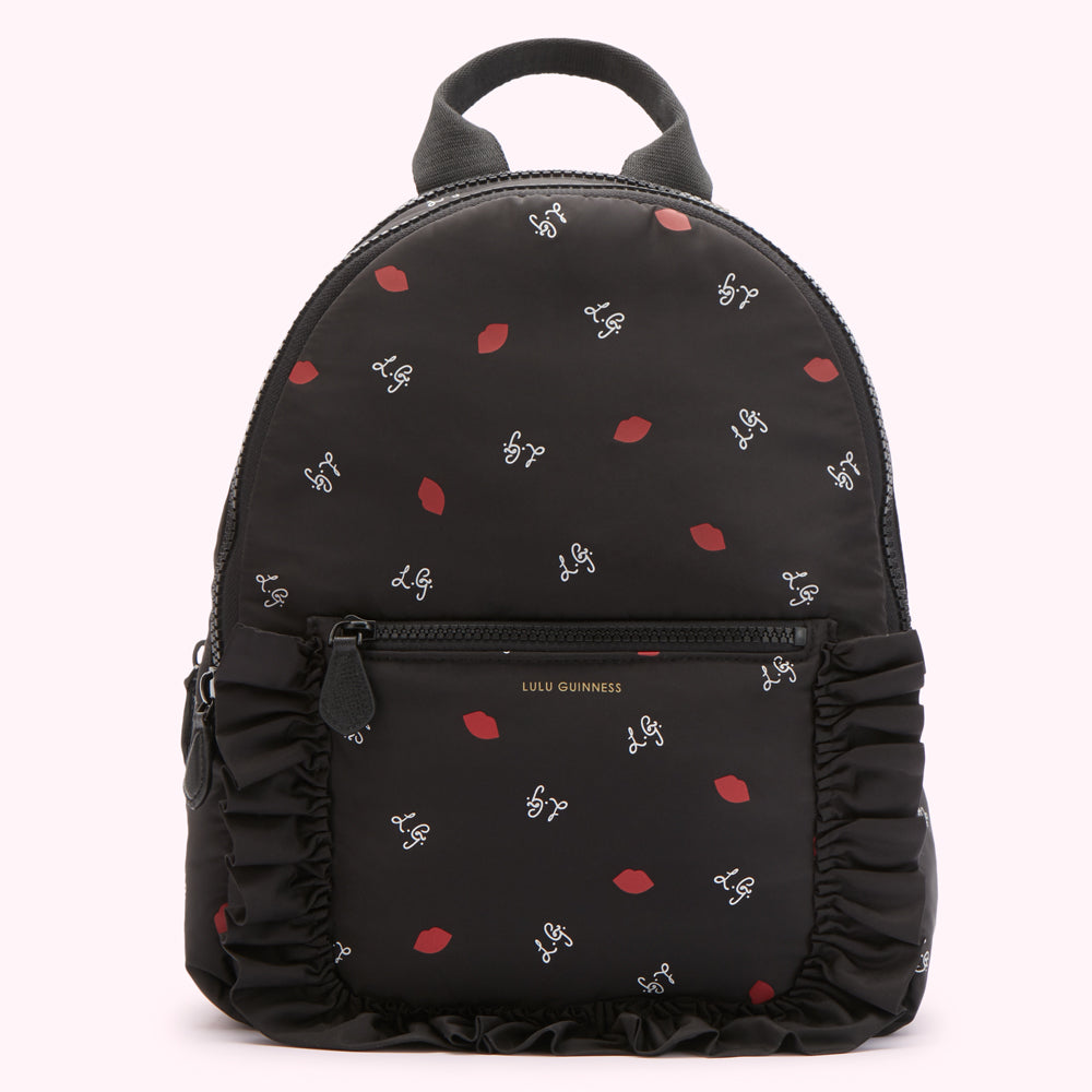 Black Lulu Guinness backpack with red lips and white L.G. logo print, and black ruffle trim.
