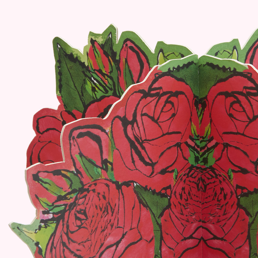 Close-up of a pop-up card featuring a bouquet of red roses with green leaves, against a white background.

