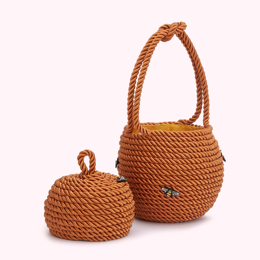 A brown rope-style handbag with a small matching lidded container; both are decorated with small bee appliqué.
