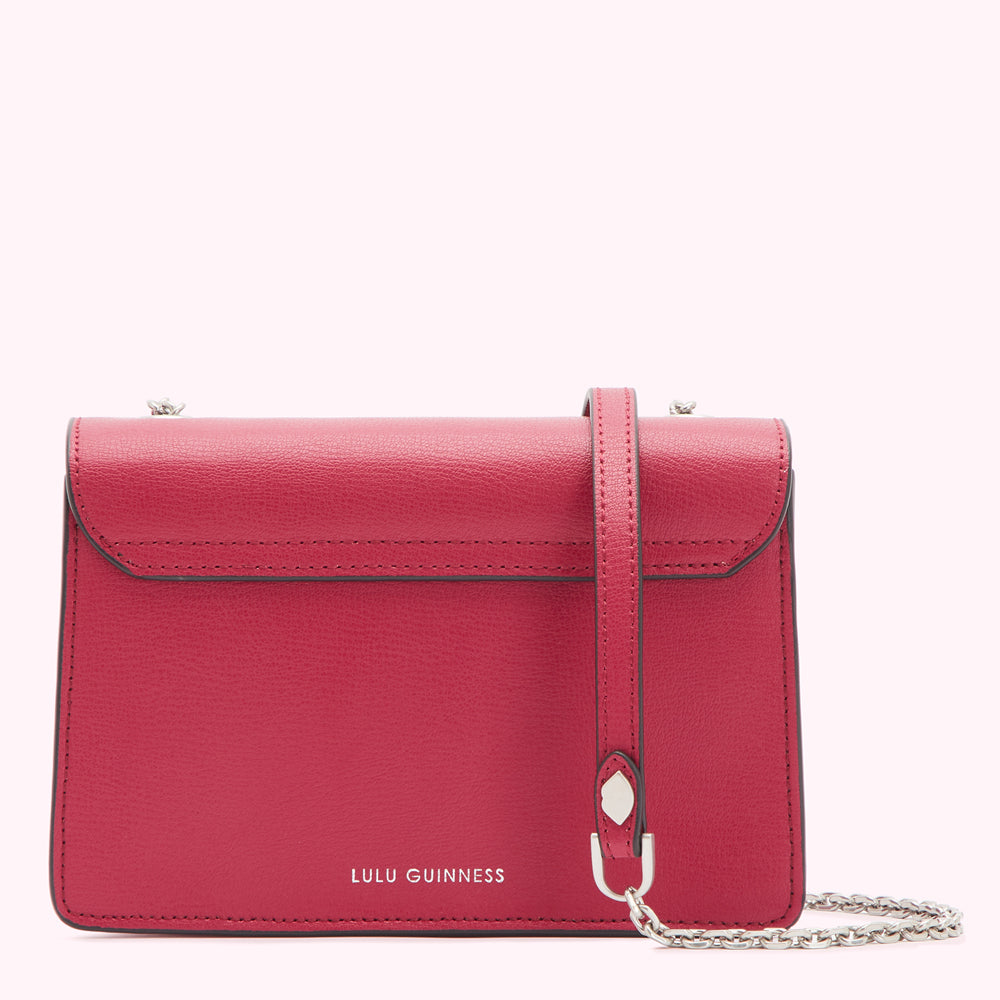 Red Lulu Guinness crossbody bag with silver chain strap.
