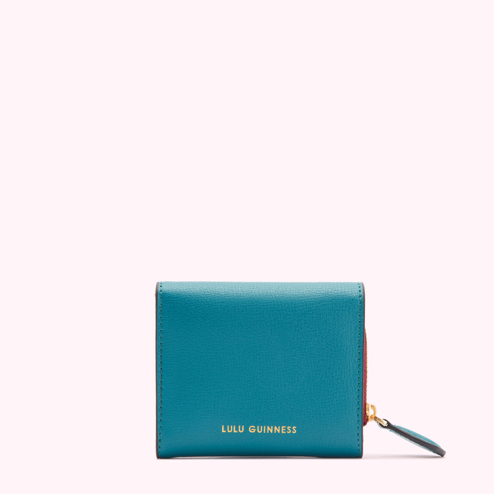 Teal Lulu Guinness wallet against a white background.
